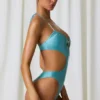 Bañador halter con aberturas y detalles de perlas de Melo Melo en turquesa
