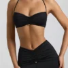 Bralette de jersey elástico con detalle de herrajes y cuello halter Jerika en negro
