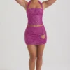 Falda micro de corte A con detalle de corazón adornado de Querida en color magenta