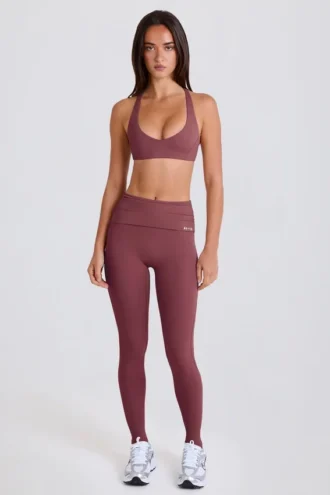 Leggings con estribos y cintura media plegable en color acai