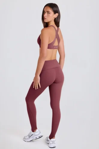 Leggings con estribos y cintura media plegable en color acai