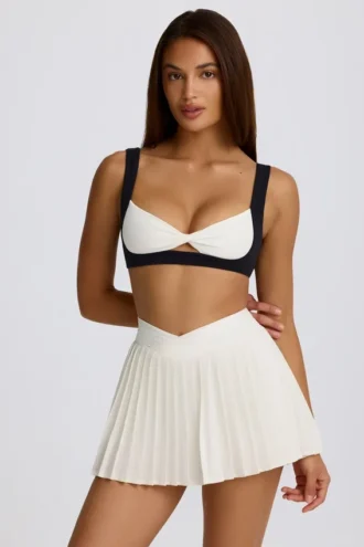 Mini falda-pantalón plisada con cruce, de tejido suave y deportivo, en color marfil