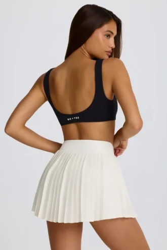 Mini falda-pantalón plisada con cruce, de tejido suave y deportivo, en color marfil
