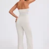 Mono bandeau de punto grueso con pantalones acampanados en color crema
