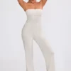 Mono bandeau de punto grueso con pantalones acampanados en color crema