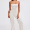Mono bandeau de punto grueso con pantalones acampanados en color crema