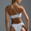 Oh Polly Ropa de baño: Top de bikini bandeau con un solo hombro y adornos, edición HOTFIX, en blanco