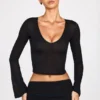Partes de arriba largas de manga larga con escote pronunciado de jersey transparente Liah en negro
