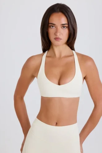 Sujetador deportivo con espalda cruzada y cuello en V en color crema