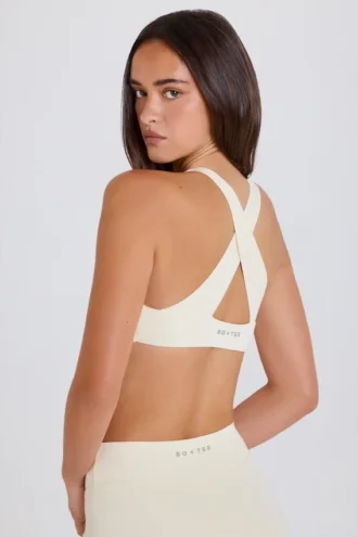 Sujetador deportivo con espalda cruzada y cuello en V en color crema