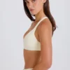 Sujetador deportivo con espalda cruzada y cuello en V en color crema