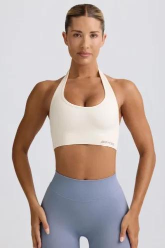 Sujetador deportivo Define Luxe con cuello halter en blanco