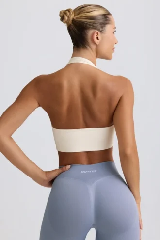 Sujetador deportivo Define Luxe con cuello halter en blanco