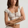 Top corsé de popelín de algodón fruncido Faela con estampado de rosas