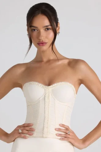 Top corsé sin tirantes con fruncidos y cordones Melvina en color marfil
