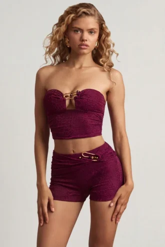Top corto bandeau Tarni con detalles metálicos en morado baya