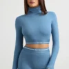 Top corto de manga larga con cuello alto y espalda descubierta en azul acero