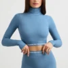 Top corto de manga larga con cuello alto y espalda descubierta en azul acero