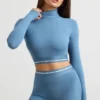 Top corto de manga larga con cuello alto y espalda descubierta en azul acero