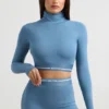 Top corto de manga larga con cuello alto y espalda descubierta en azul acero