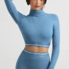 Top corto de manga larga con cuello alto y espalda descubierta en azul acero