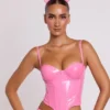 Top corto tipo corsé con aros de vinilo Cassandra en rosa