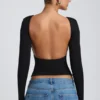 Top Elli de modal con cuello alto, manga larga y espalda abierta en negro