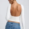 Top Elli de modal, cuello alto, manga larga y espalda abierta en blanco
