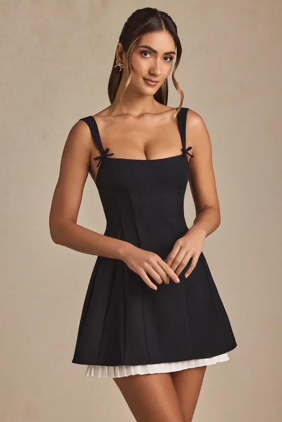 Vestido corto A-line plisado con lazo Cressida en negro Vestido corto A-line plisado con lazo Cressida en negro