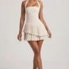 Vestido corto asimétrico con capas y cuello halter Rosaria en color marfil