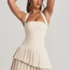 Vestido corto asimétrico con capas y cuello halter Rosaria en color marfil