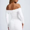 Vestido corto blanco con hombros descubiertos y aberturas, con detalles metálicos, en color azafrán
