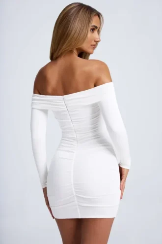 Vestido corto blanco con hombros descubiertos y aberturas, con detalles metálicos, en color azafrán