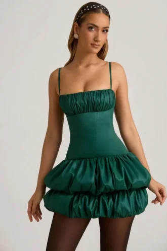 Vestido corto Clarice de satén con bajo abullonado y corsé en verde esmeralda