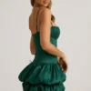 Vestido corto Clarice de satén con bajo abullonado y corsé en verde esmeralda