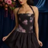 Vestido corto con cuello halter, cordones y bajo abullonado Nanala en estampado floral negro