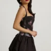Vestido corto con cuello halter, cordones y bajo abullonado Nanala en estampado floral negro