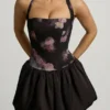 Vestido corto con cuello halter, cordones y bajo abullonado Nanala en estampado floral negro