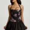 Vestido corto con cuello halter, cordones y bajo abullonado Nanala en estampado floral negro