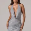 Vestido corto con cuello vuelto y espalda baja adornado con velar en color plateado