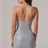 Vestido corto con cuello vuelto y espalda baja adornado con velar en color plateado