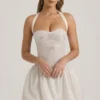 Vestido corto Felicity con cuello halter y bajo abullonado, con adornos, en color marfil Vestido corto Felicity con cuello halter y bajo abullonado, con adornos, en color marfil