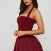 Vestido corto Ludmila con cuello halter, cordones y bajo abullonado en rojo baya Vestido corto Ludmila con cuello halter, cordones y bajo abullonado en rojo baya