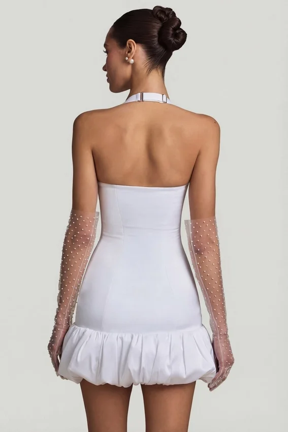 Vestido corto Millie con cuello halter, detalle de lazo y bajo abullonado en blanco Vestido corto Millie con cuello halter, detalle de lazo y bajo abullonado en blanco