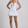 Vestido corto Millie con cuello halter, detalle de lazo y bajo abullonado en blanco Vestido corto Millie con cuello halter, detalle de lazo y bajo abullonado en blanco