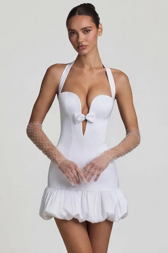 Vestido corto Millie con cuello halter, detalle de lazo y bajo abullonado en blanco Vestido corto Millie con cuello halter, detalle de lazo y bajo abullonado en blanco