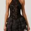 Vestido corto Petalia con volantes y cuello halter adornado en negro Vestido corto Petalia con volantes y cuello halter adornado en negro