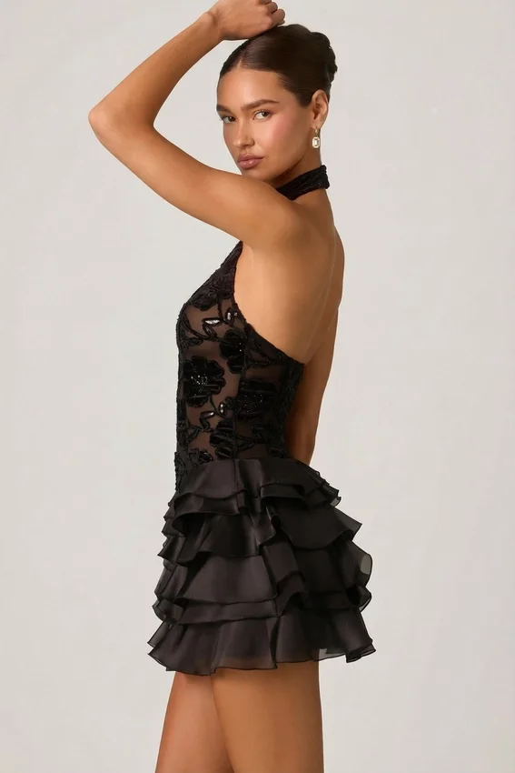 Vestido corto Petalia con volantes y cuello halter adornado en negro Vestido corto Petalia con volantes y cuello halter adornado en negro