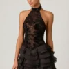 Vestido corto Petalia con volantes y cuello halter adornado en negro Vestido corto Petalia con volantes y cuello halter adornado en negro