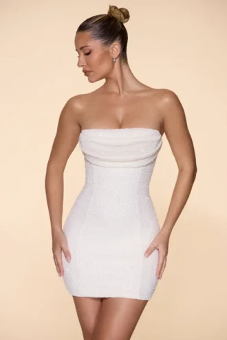 Vestido corto sin tirantes con cuello cowl y adornos de Basel en color marfil